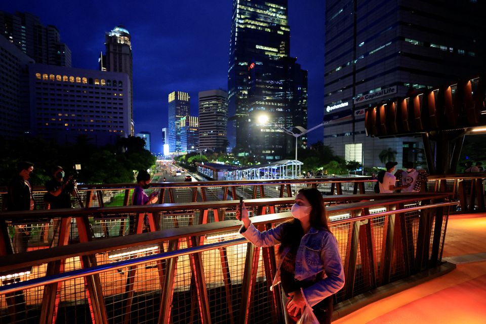 People wearing protective masks enjoy a pedestrian bridge in Jakarta, Indonesia, March 15, 2022. /Reuters