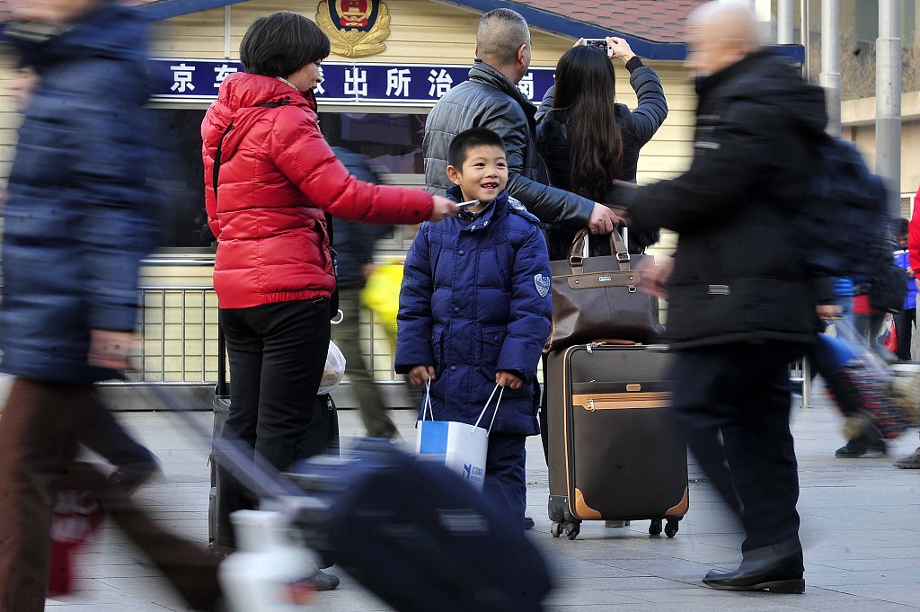 A boy stands at the square of Beijing Railway Station in Beijing, China, January 15, 2014. /CFP
