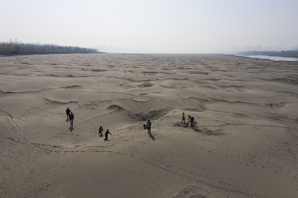 People in Wuhan City of central China's Hubei Province walking on the exposed river bed during the Yangtze River's worst drought in 61 years. /VCG