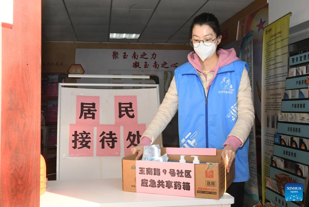 A staff member puts a shared medical kit at the entrance of a residential community in Yangfangdian Subdistrict of Haidian District in Beijing, capital of China, December 27, 2022. /Xinhua