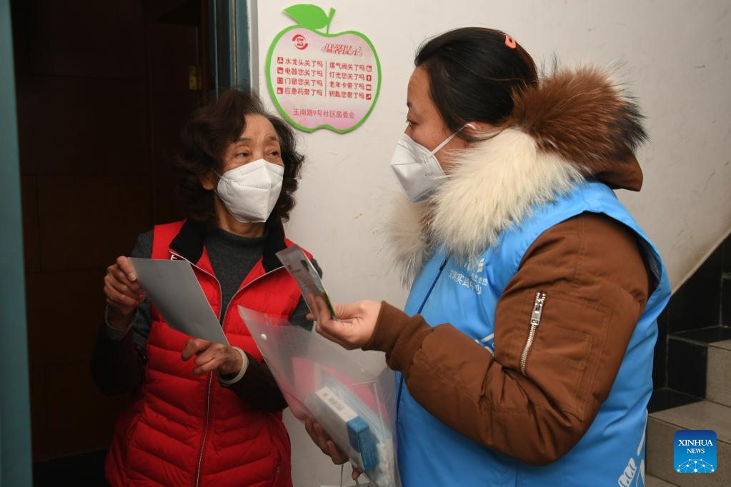 A community worker (R) talks with a resident in a community in Yangfangdian Subdistrict of Haidian District in Beijing, capital of China, December 27, 2022. /CFP
