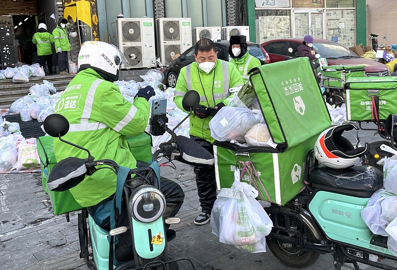 Courier workers at a food delivery point in Dongcheng District, Beijing, December 17, 2022. /CFP