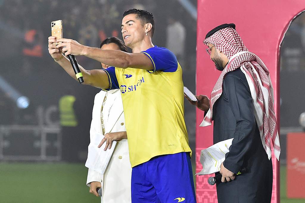 Cristiano Ronaldo (C) poses for a selfie with the presenters during his unveiling at the Mrsool Park Stadium in Riyadh, Saudi Arabia, January 3, 2023. /CFP