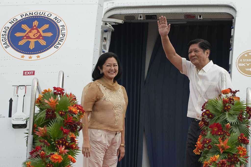 Philippine President Ferdinand Marcos Jr., right, waves beside wife Maria Louise as they board a plane for China on Tuesday, Jan. 3, 2023. /CFP