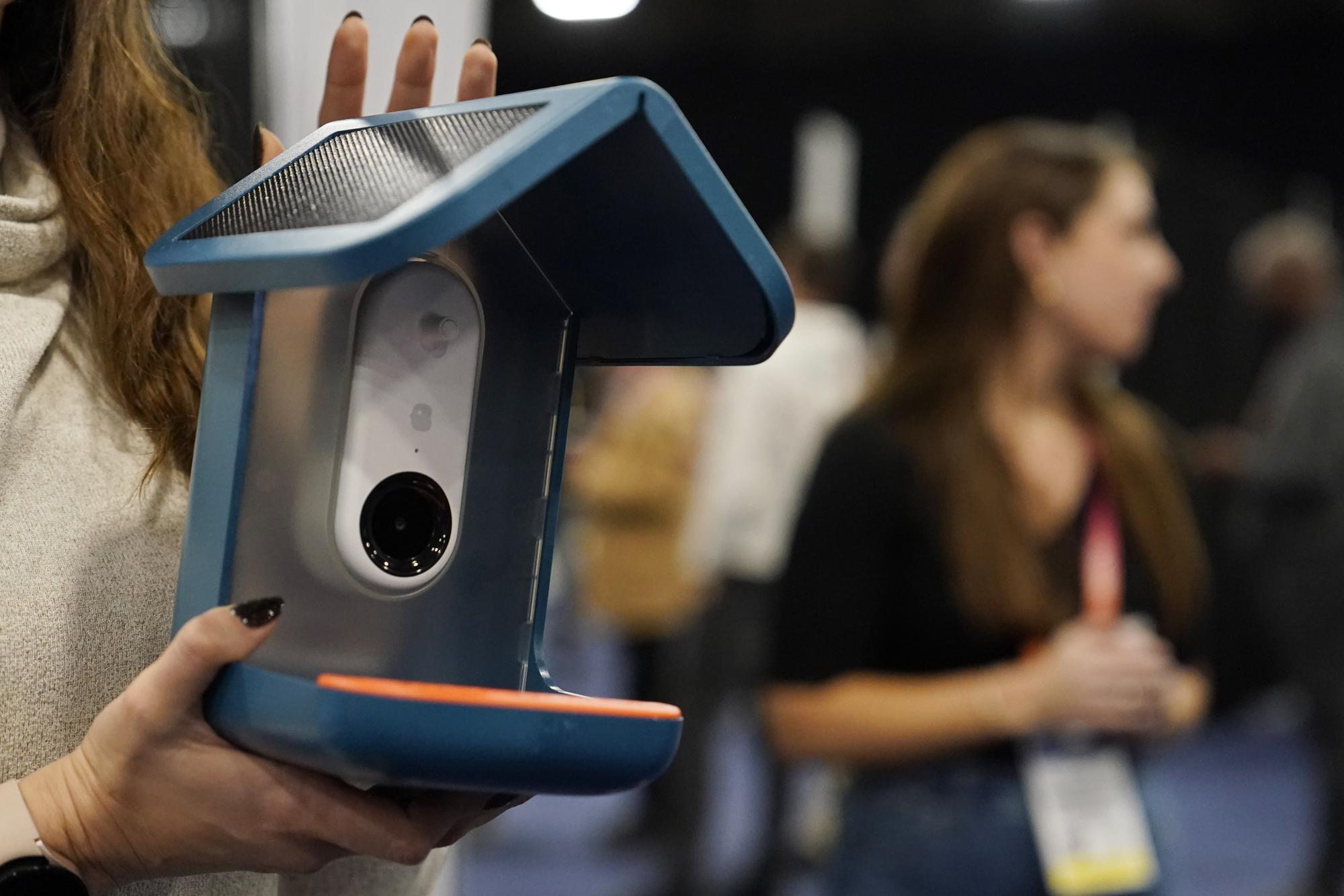 An exhibitor holds up the Bird Buddy smart camera bird feeder during CES Unveiled. /AP