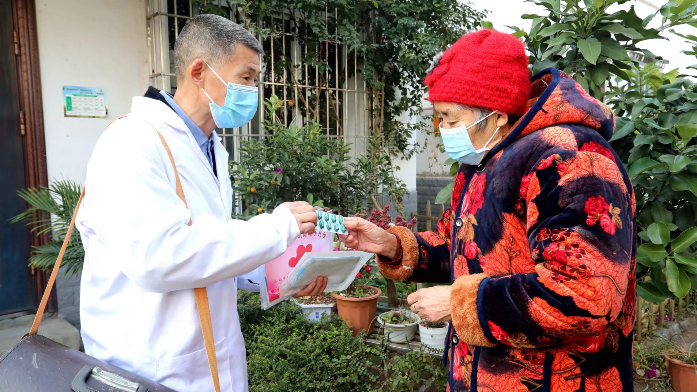 A village doctor tells an elderly woman how to take medicines from an anti-COVID-19 package, Pengcun Village, Renshou County, Meishan, Sichuan Province, China, December 29, 2022. /CFP
