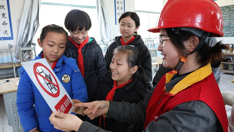 An employee of Baojing County Power Supply Company explains safe electricity use to children at Mawang Primary School in Qingshuiping Town, Xiangxi Tujia and Miao Autonomous Prefecture, central China's Hunan Province, November 28, 2022. /CFP