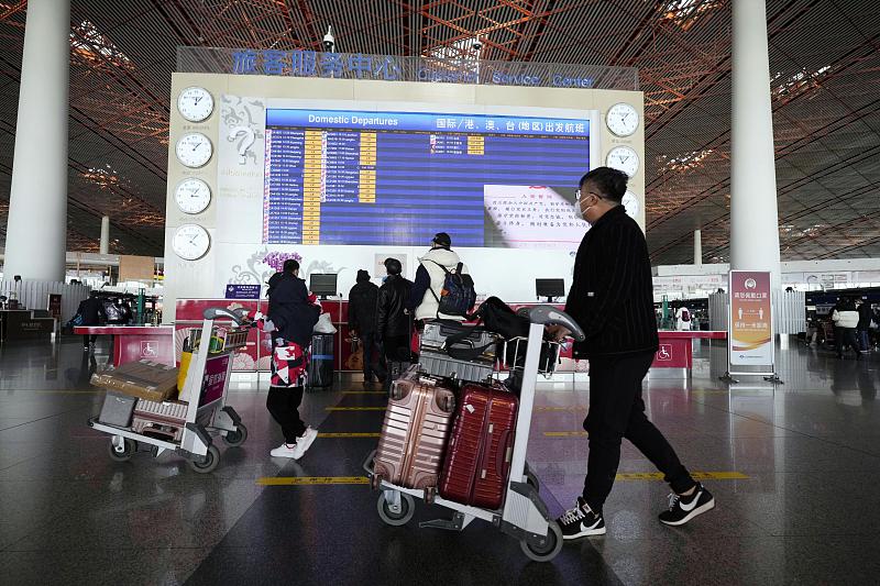 Travelers walk through a departure lobby at Beijing Capital International Airport, China, December 27, 2022. /CFP