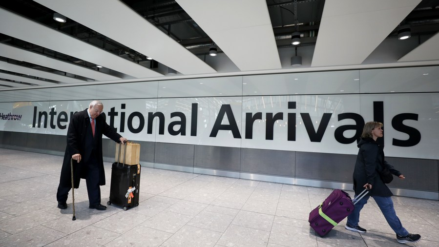 Passengers walk at the international arrivals area in Heathrow Airport in London, Britain, March 18, 2022. /Xinhua