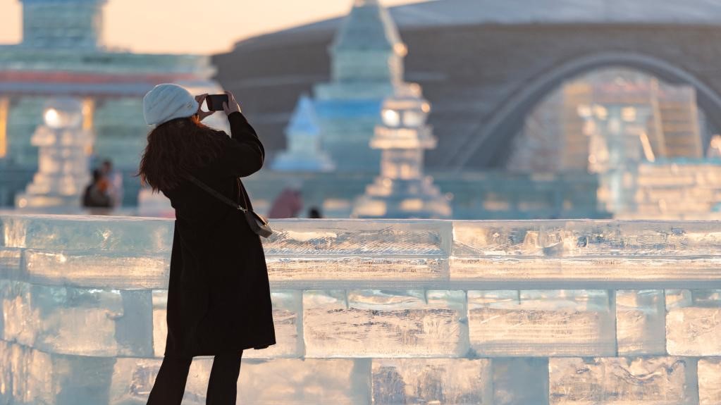 A tourist takes pictures at the Harbin Ice-Snow World theme park in Harbin, northeast China's Heilongjiang Province, January 5, 2023. /Xinhua