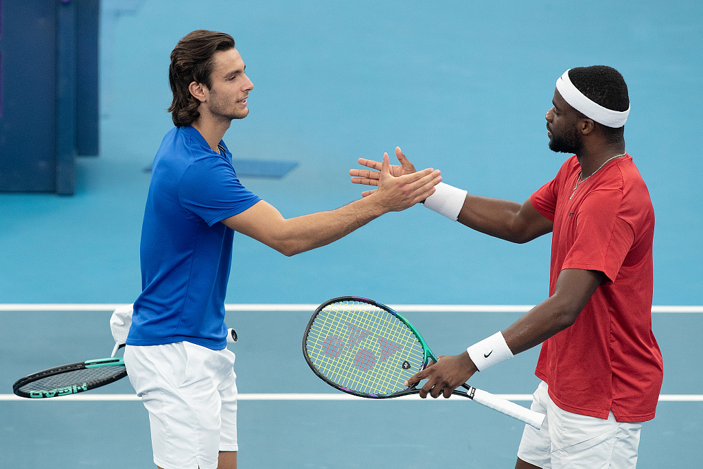 Lorenzo Musetti of Italy (L) shakes hands with Frances Tiafoe of the United States after retiring from shoulder injuries in the final of the inaugural United Cup mixed team tournament in Sydney, Australia, January 8, 2023. /CFP