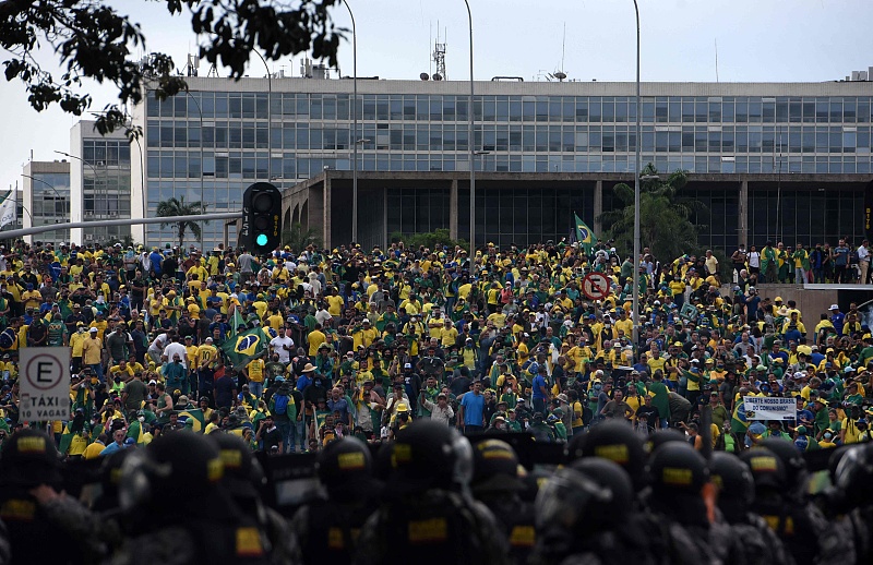 Supporters of Brazilian former President Jair Bolsonaro invading several governmental building are confronted by security forces (foreground) in Brasilia, January 8, 2023. /CFP
