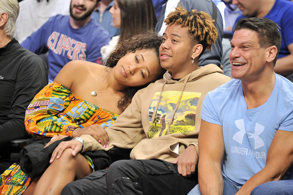 Naomi Osaka rests on her boyfriend Cordae's shoulder as they attend a basketball game between the Los Angeles Clippers and the Washington Wizards at Staples Center in California, U.S., December 1, 2019. /CFP