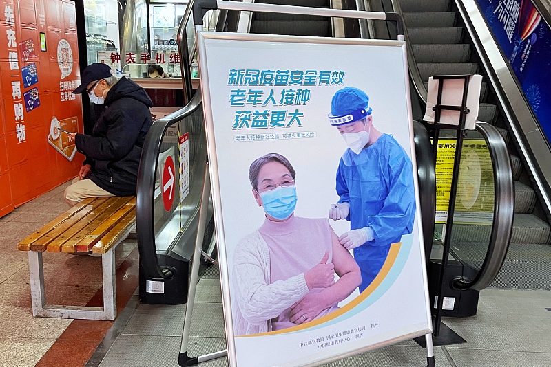 Posters promoting the benefits of COVID-19 vaccination for the elderly are seen at the entrance of a supermarket in Daxing district, Beijing, January 8, 2023. /CFP