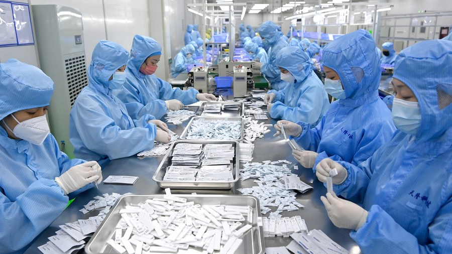 Employees produce antigen test kits for COVID-19 at a medical equipment company in Xi'an, northwest China's Shaanxi Province, January 4, 2023. /Xinhua