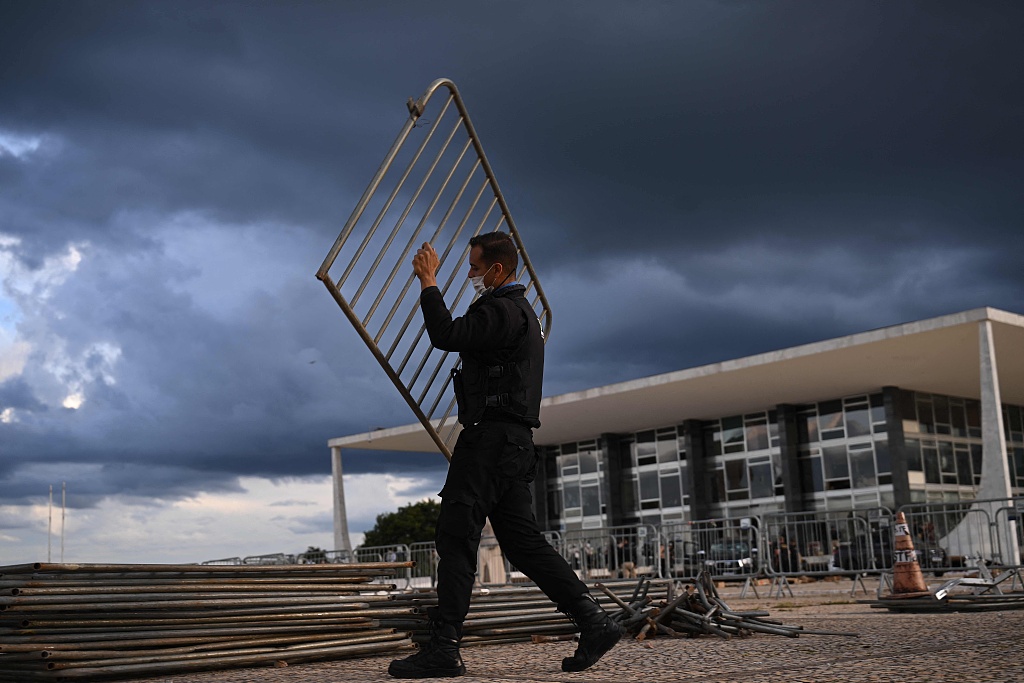 A Federal Police officer removes fences outside the Supreme Court building in Brasilia, two days after thousands of supporters of Brazil's ex-President Jair Bolsonaro raided federal buildings, January 10, 2023. /CFP