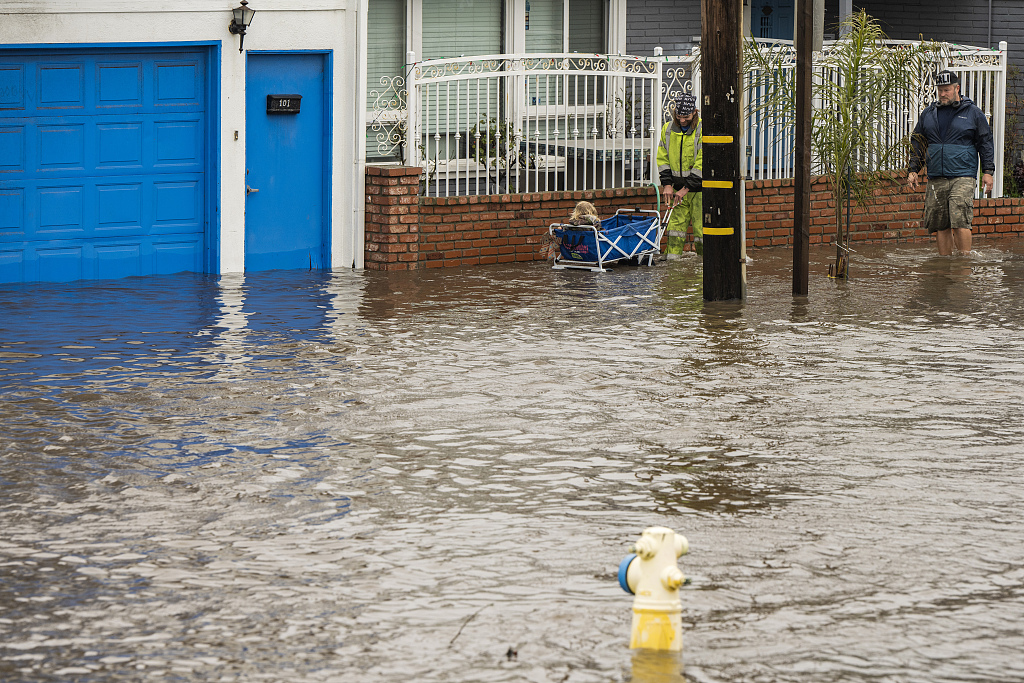 Pedestrians wade through floodwaters in Aptos, California, U.S., January 14, 2023. /CFP