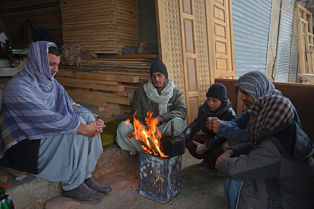 Afghan men warm themselves around a fire at a market in Kandahar, Afghanistan, January 12, 2023. /CFP