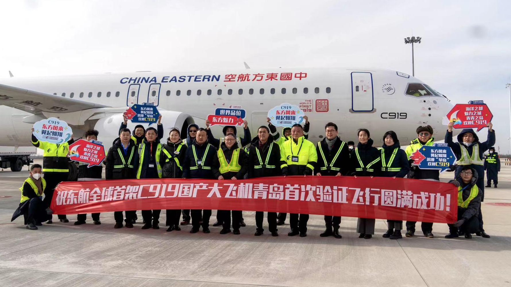 Staff members pose for a group photo after China's first China Eastern Airlines (CEA) C919 large passenger jet landed in Qingdao City in east China's Shandong Province, January 15, 2023. /China Media Group