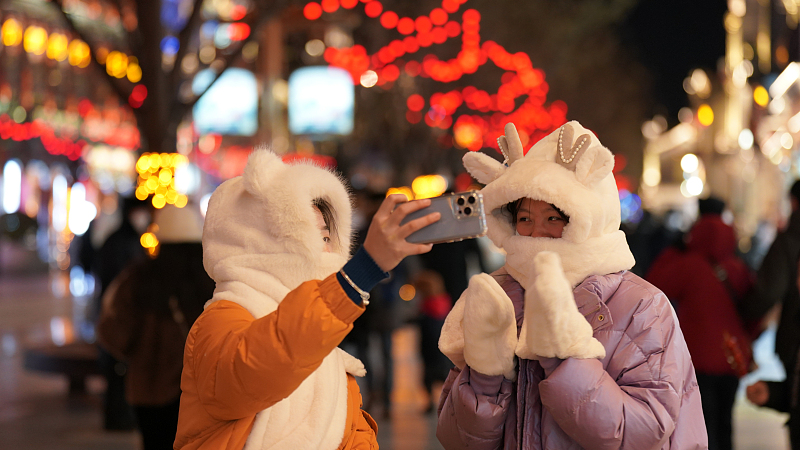 Two pedestrians take a selfie together on Qianmen Street in Beijing, capital of China, January 16, 2023. /CFP