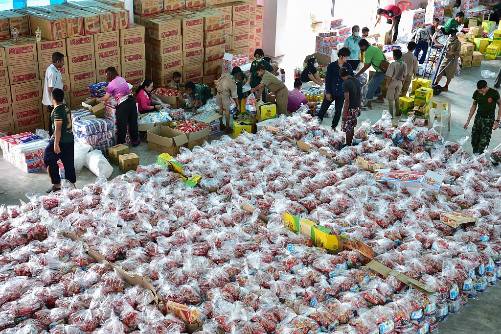 Soldiers, students and volunteers pack bags of food to distribute to flood victims following heavy rains at a school in Narathiwat, Thailand, December 21, 2022. /CFP