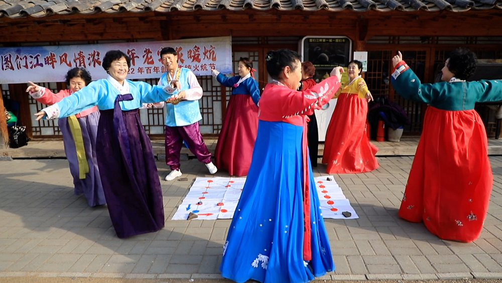 Residents of Bailong Village play a traditional Korean game called Yut. /CGTN
