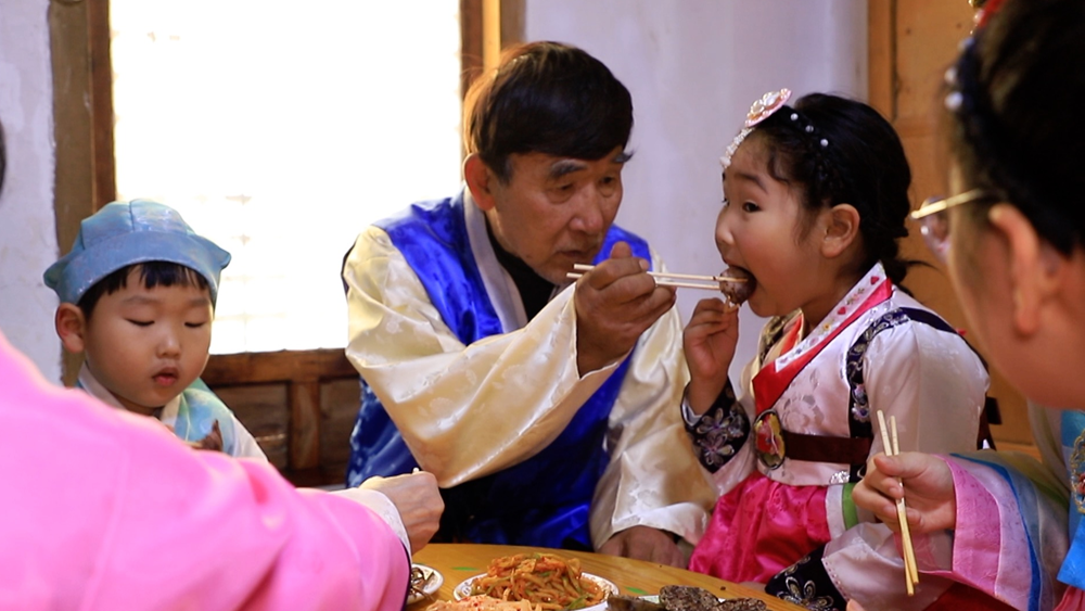 Family of Jin Jingnan (C) enjoy their dinner in Bailong Village, Tumen City, Yanbian Korean Autonomous Prefecture, Jilin Province, northeast China. /CGTN