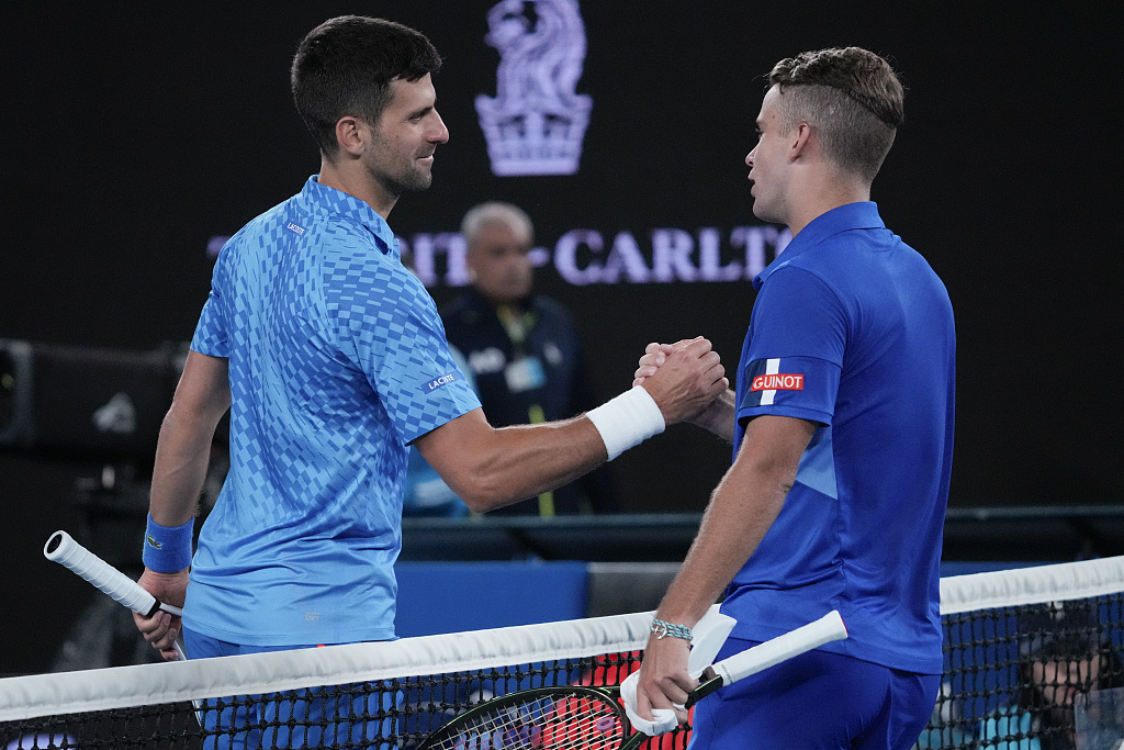 Novak Djokovic of Serbia (L) shakes hands with Enzo Couacaud of France following their men's singles second round match at the Australian Open, January 19, 2023. /CFP