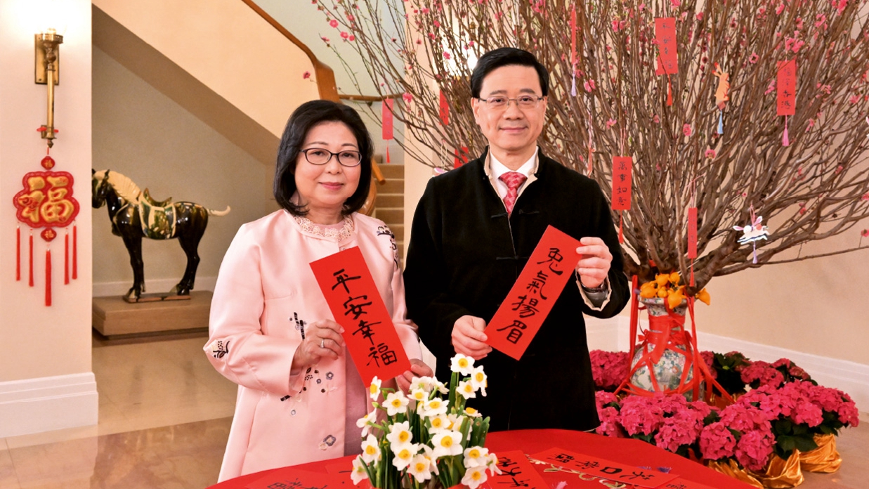 Chief Executive of the Hong Kong Special Administrative Region John Lee (R) and his wife Janet Lam deliver a New Year message, January 21, 2023. /China's HKSAR government