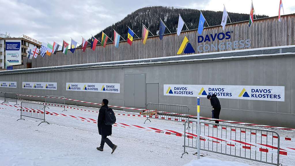 People pass by country flags as 53rd World Economic Forum (WEF), also known as Davos Summit starts in Davos, Switzerland, January 16, 2023. /CFP