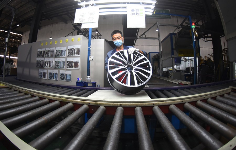 A man works on an automobile wheel hub production line at an aluminum product manufacturer in Lianyungang, east China's Jiangsu Province, October 27, 2022.