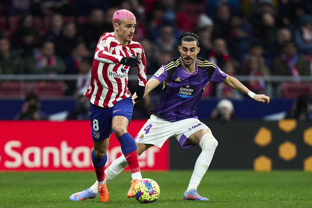Antoine Griezmann (L) of Atletico Madrid battles for the ball with Kike Perez of Real Valladolid during their La Liga match at Metropolitano Stadium in Madrid, Spain, January 21, 2023. /CFP