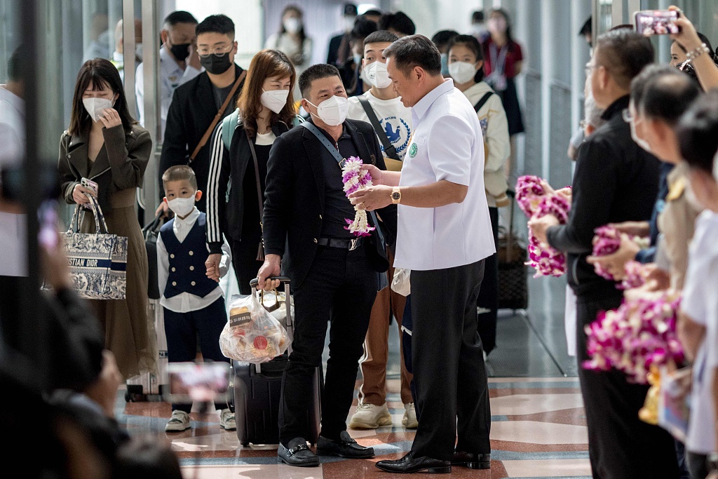 Thai Health Minister Anutin Charnvirakul welcomes travelers from China as they arrive at Suvarnabhumi Airport in Bangkok, January 9, 2023. /CFP