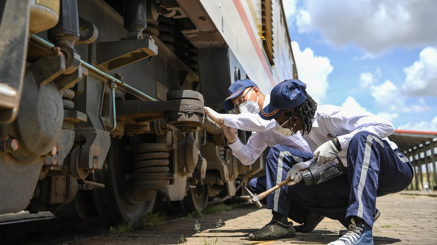 Staff members check a train at Nairobi station of Mombasa-Nairobi Standard Gauge Railway (SGR) in Nairobi, Kenya, March 22, 2021. /Xinhua