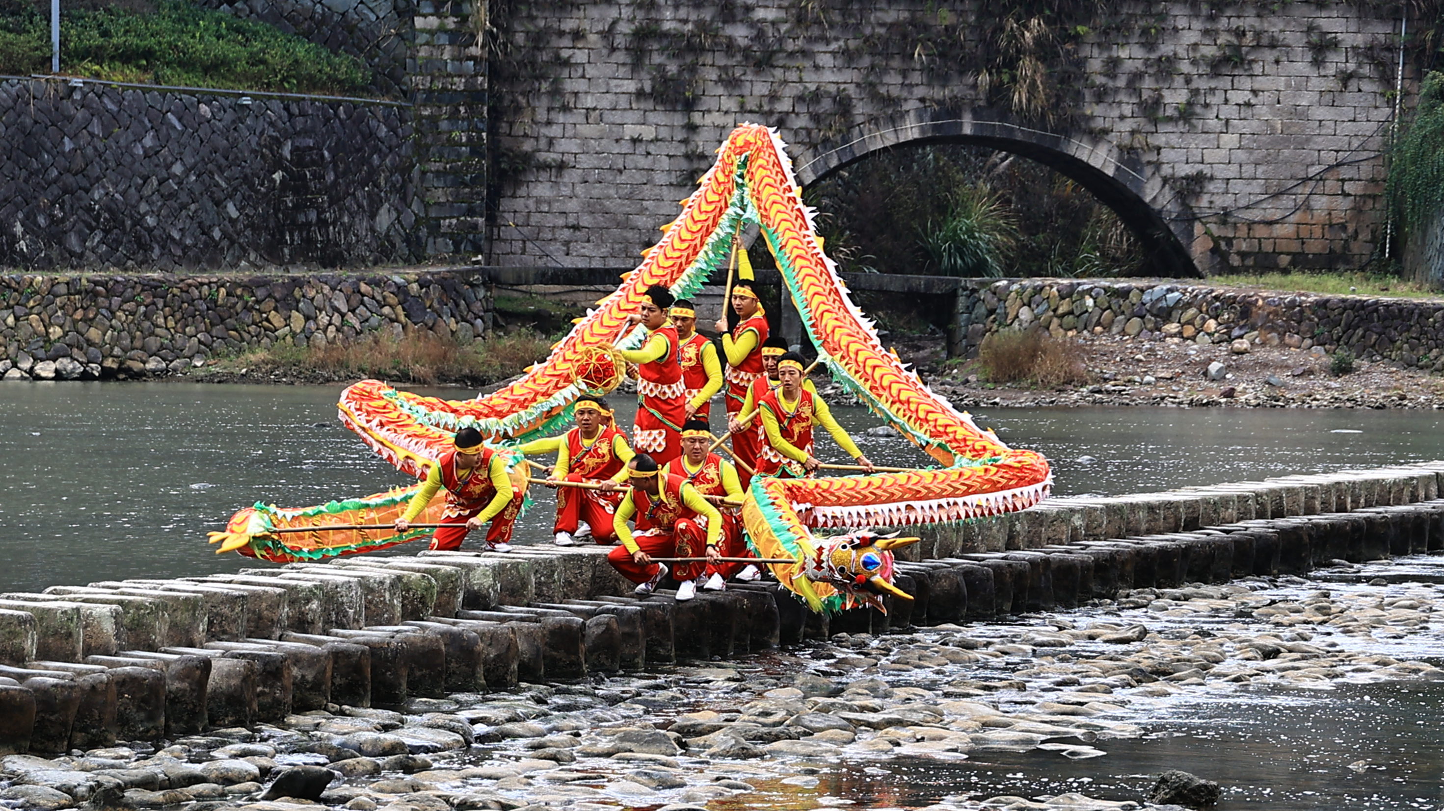 Folklore artists perform dragon dances on the Shishui Stepping Stone Bridge in Zhejiang. /CFP