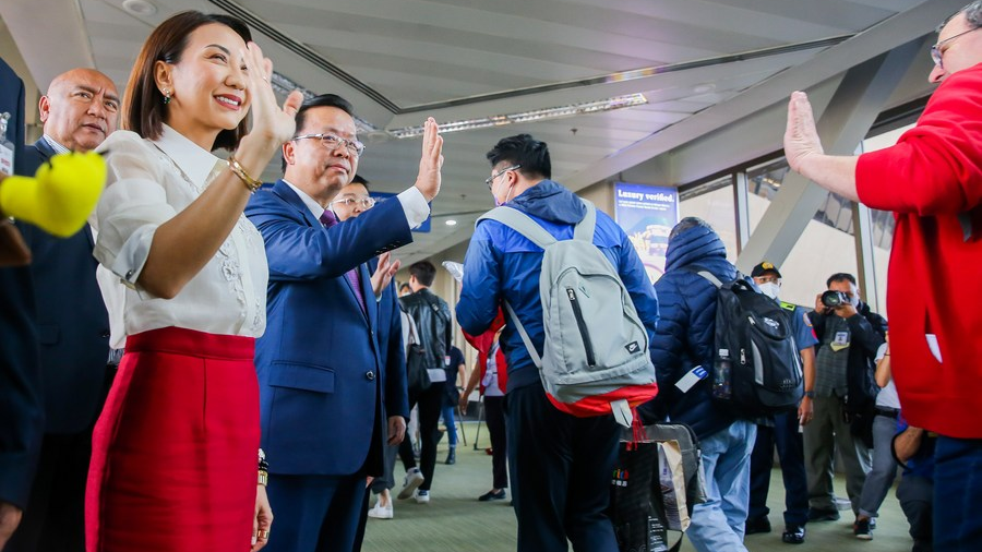 Philippine Tourism Secretary Christina Frasco (2nd L) and Chinese Ambassador to the Philippines Huang Xilian (3rd L) greet tourists from China at the Ninoy Aquino International Airport Terminal 1 in Pasay City, the Philippines, January 24, 2023. /Xinhua