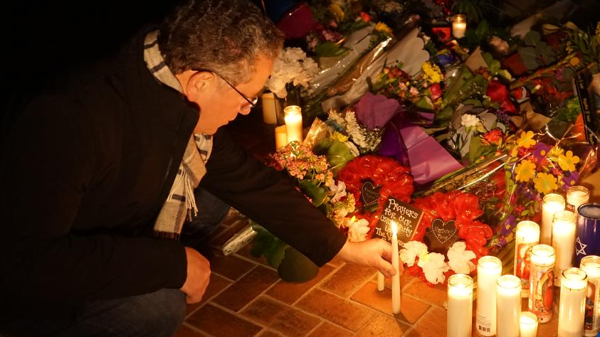 A man places a candle to mourn victims of a mass shooting in front of the city hall of Monterey Park, California, U.S., January 23, 2023. /Xinhua