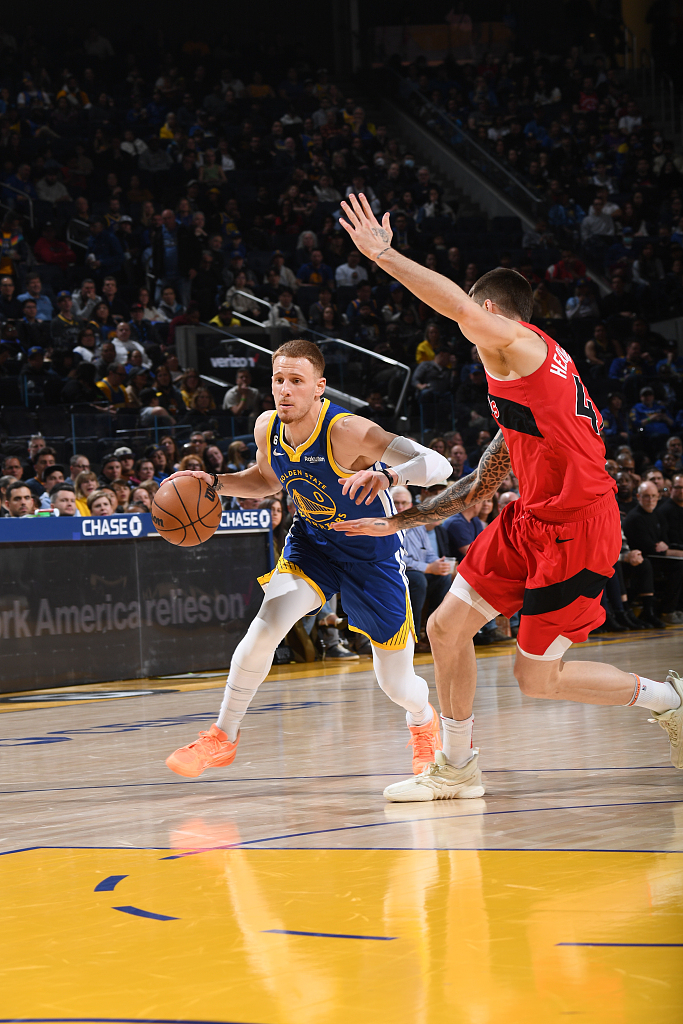 Donte DiVincenzo (L) of the Golden State Warriors penetrates in the game against the Toronto Raptors at the Chase Center in San Francisco, California, January 27, 2023. /CFP