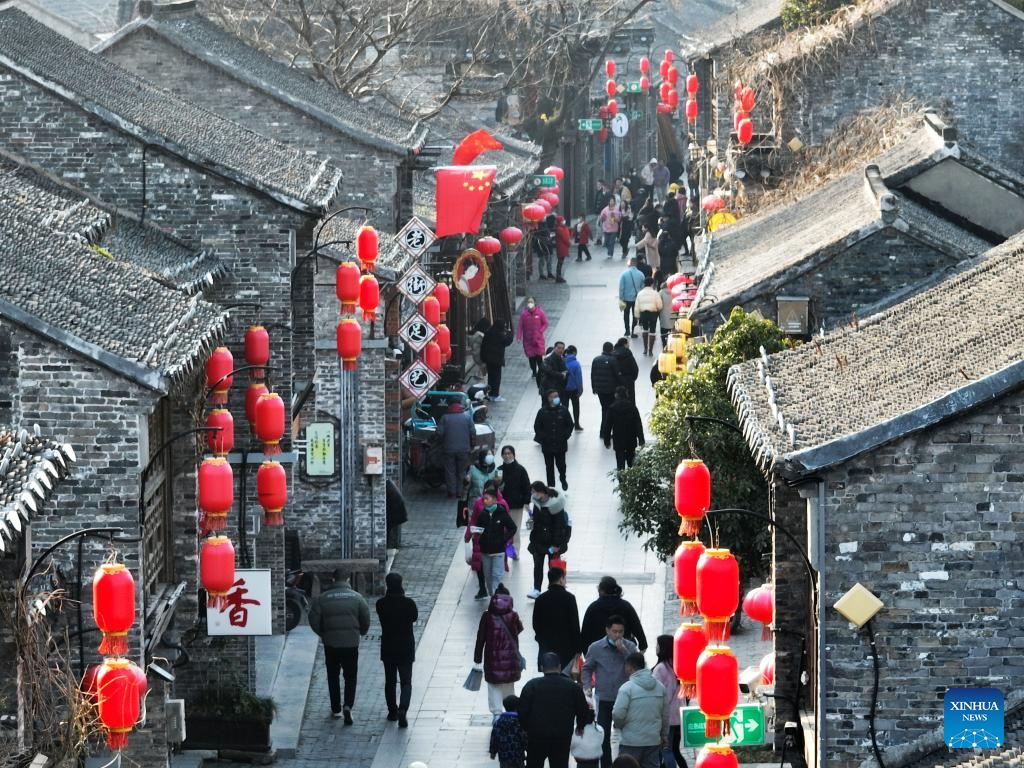An aerial photo shows tourists visiting Dongguan Street decorated with red lanterns in Yangzhou City, east China's Jiangsu Province, January 18, 2023 /Xinhua