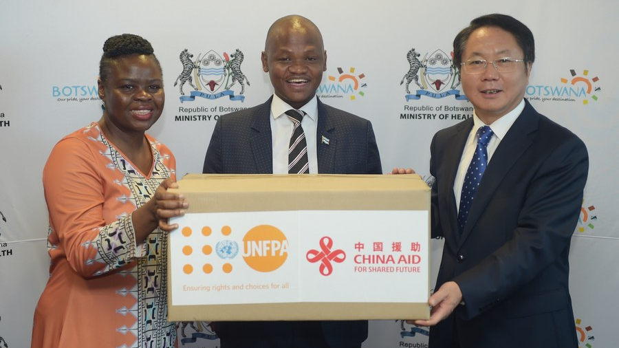 Botswana Health Minister Edwin Dikoloti (C), Chinese Ambassador to Botswana Wang Xuefeng (R) and a UNFPA official pose for a group photo during the handover ceremony of personal protective equipment and reproductive health products donated by China in Gaborone, Botswana, January 27, 2023. /Xinhua