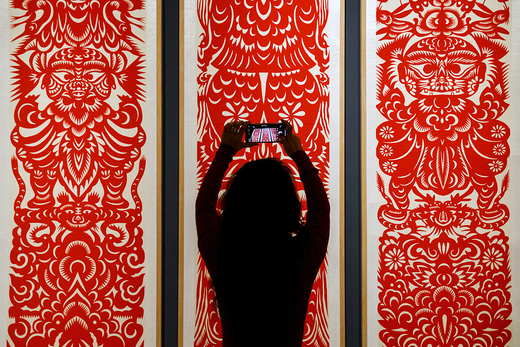 A visitor takes a picture at the China National Arts and Crafts Museum and China Intangible Cultural Heritage Museum in Beijing. /CFP