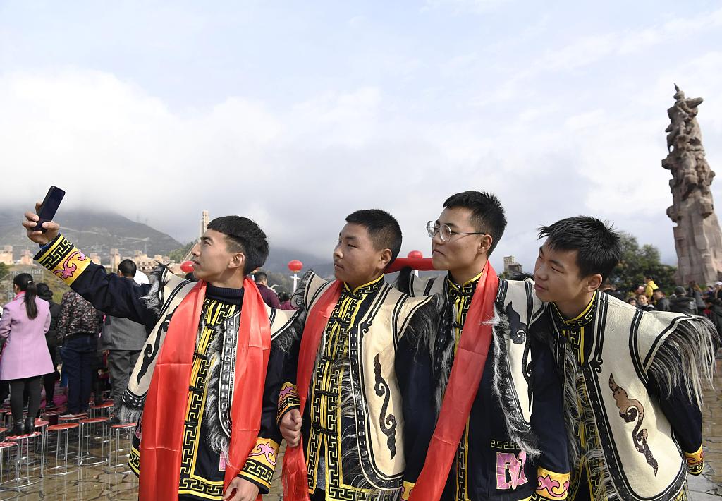 Young people participating in the Qiang New Year festival event take selfies. /CFP