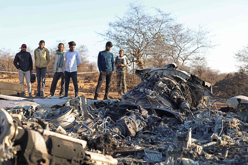 People stand next to plane wreckage after a Sukhoi Su-30 fighter jet and a Dassault Mirage 2000 crashed during exercises in Pahadgarh area, 50 kilometers from Gwailor, India, January 29, 2023. /CFP
