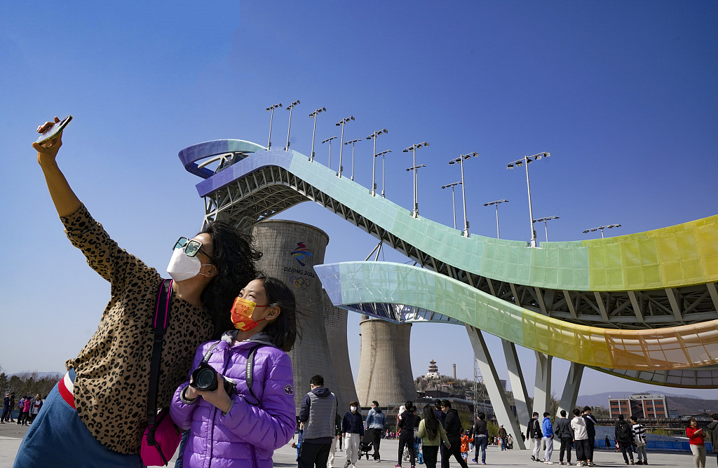Visitors take a selfie at the Shougang Ski Jumping Park in Beijing, China, April 3, 2022. /CFP