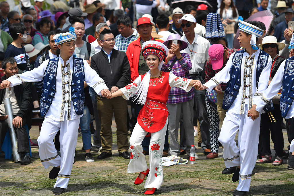 Bai people perform a dance for an audience at a folk carnival-like festival in Kunming, Yunnan Province, on May 1, 2018. /CFP