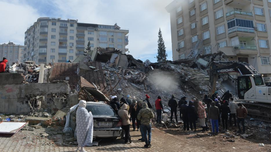People gather around the rubble of a building destroyed in a powerful earthquake in Kahramanmaras, Türkiye, on February 7, 2023. /Xinhua
