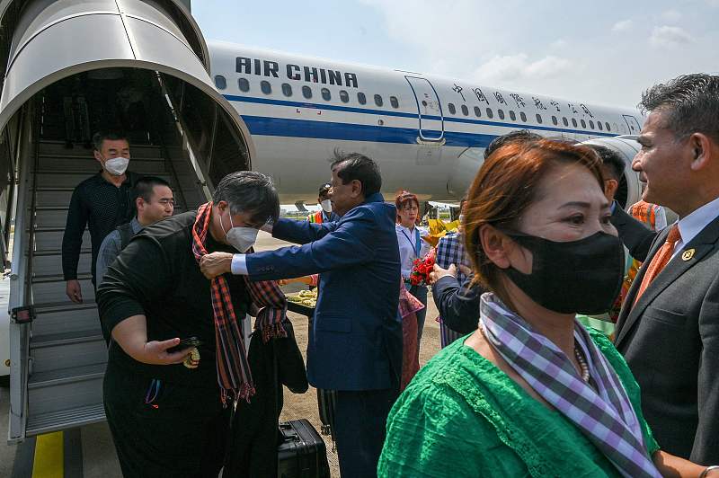 Cambodia's Tourism Minister Thong Khon offers a scarf to a Chinese tourist upon their arrival during a welcoming ceremony at Phnom Penh International Airport in Phnom Penh, Cambodia, February 7, 2023. /CFP