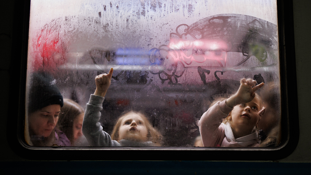 Two girls paint the foggy glass of one of the carriages at the Lviv train station, Ukraine, March 2, 2022. /CFP