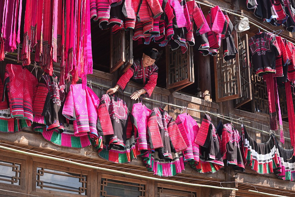 A woman dries traditional clothing of the Red Yao ethnic group. /CFP