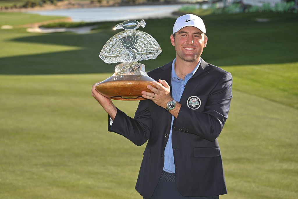 American golfer Scottie Scheffler holds the trophy on the 18th green after the final round of the Phoenix Open at TPC Scottsdale in Scottsdale, U.S., February 12, 2023. /CFP